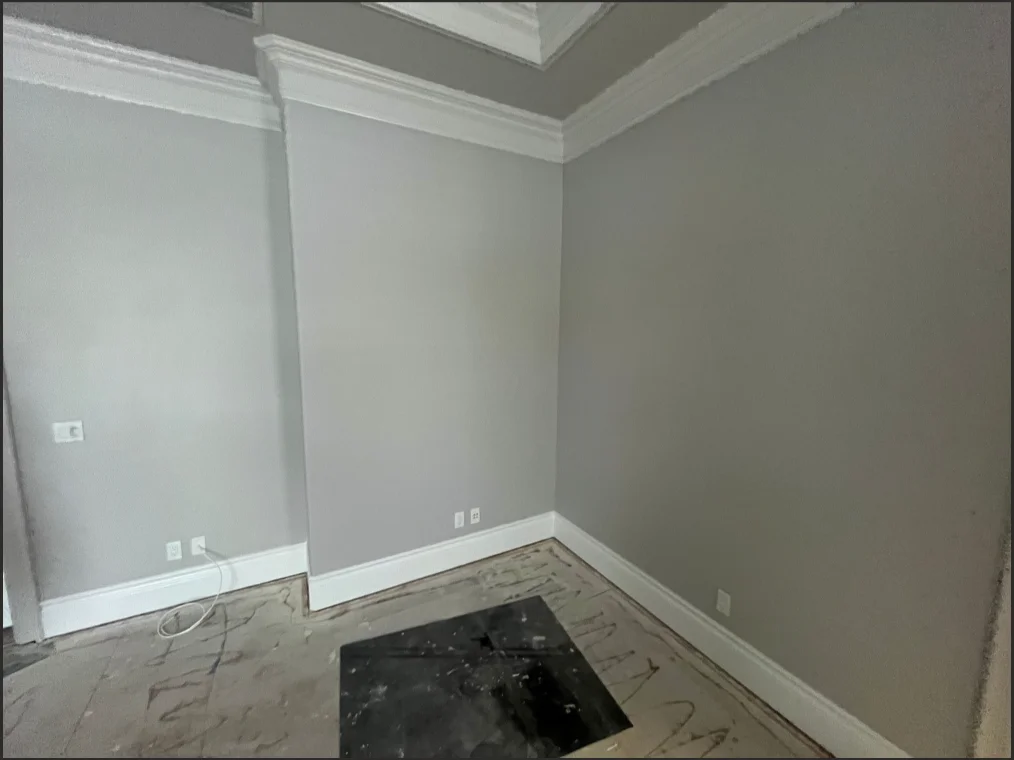 Interior room with freshly painted gray walls, white trim, and crown molding