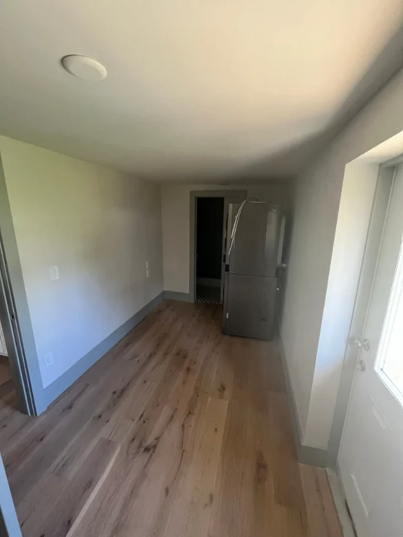Newly painted interior hallway with neutral walls, smooth ceiling, and laminate flooring