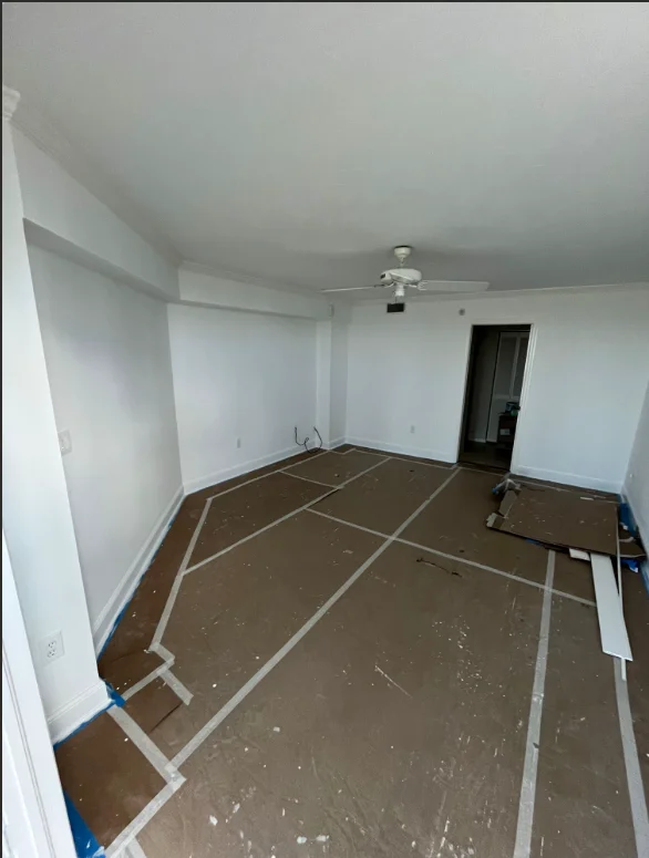 Interior room with taped drywall sections and protective floor coverings ready for painting