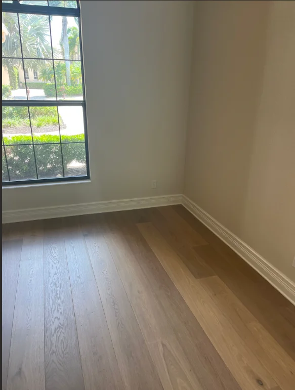 Newly painted room with neutral walls, white trim, and light wood flooring