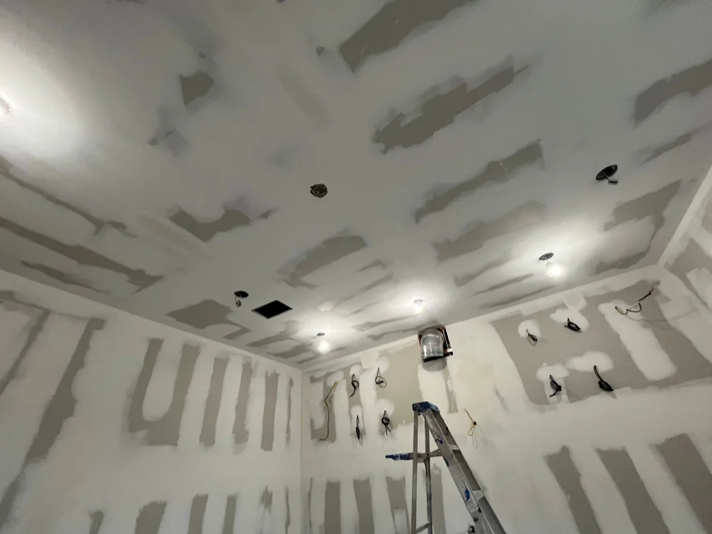 Finished drywall ceiling with recessed lights and taped seams in Naples home