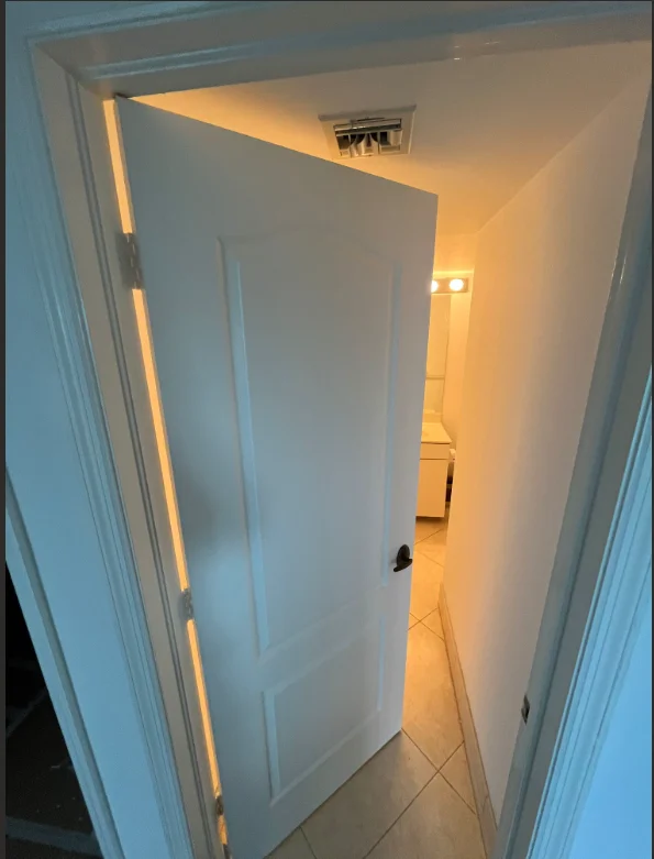 Freshly painted white hallway with warm LED accent lighting along door frame