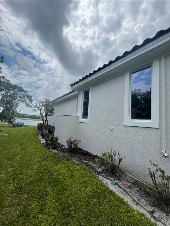 White painted residential home exterior with windows and manicured lawn in Naples