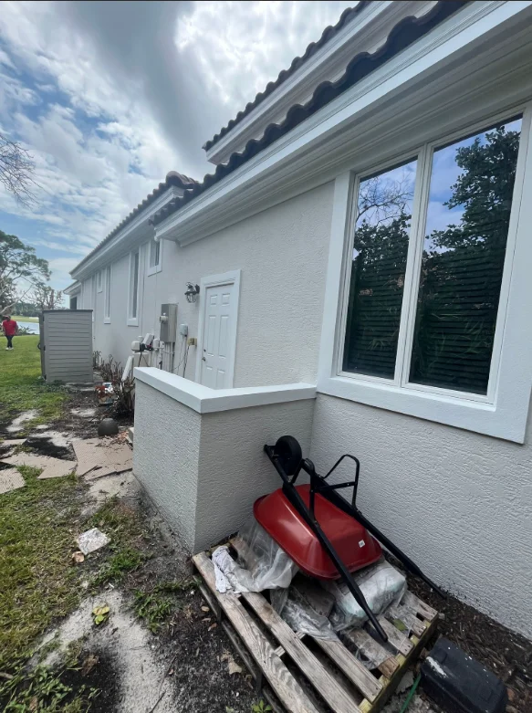 White painted residential exterior with new trim and large multi-pane windows